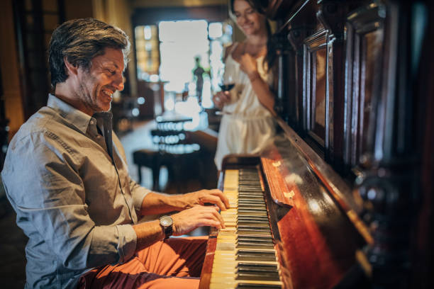istock Man playing piano for his girlfriend in restaurant 1203166490