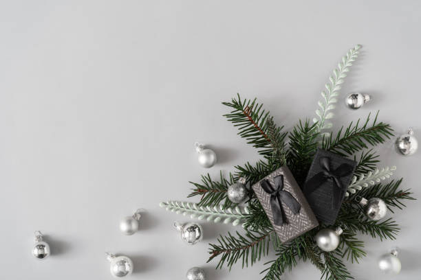 istock Creative winter nature layout made with fir branches, presents and Christmas baubles against pastel grey background. 1203166582