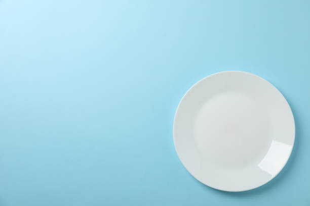 istock Plate on blue background, top view and space for text 1203166870