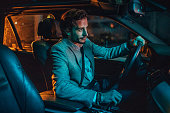 Modern man driving a car in city at night