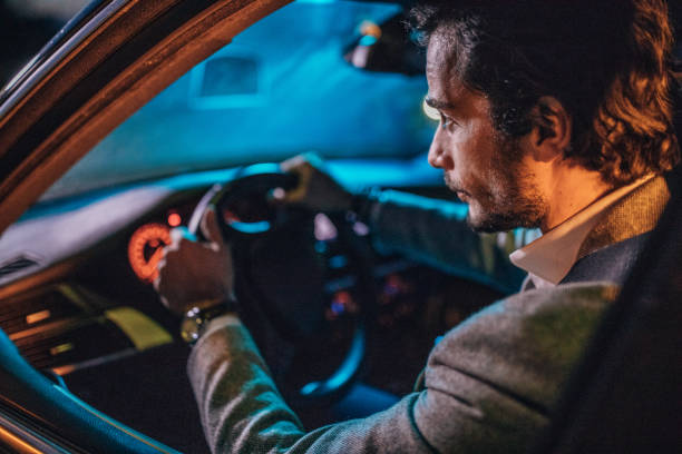 istock Gentleman driving a car at night 1203168286