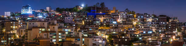 istock Crowded housing on hillside warmly illuminated night panorama Seoul Korea 1203170337