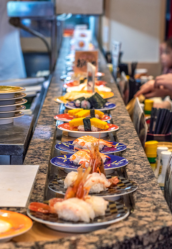 sushi dishes go around on the conveyor belt restaurant in japan