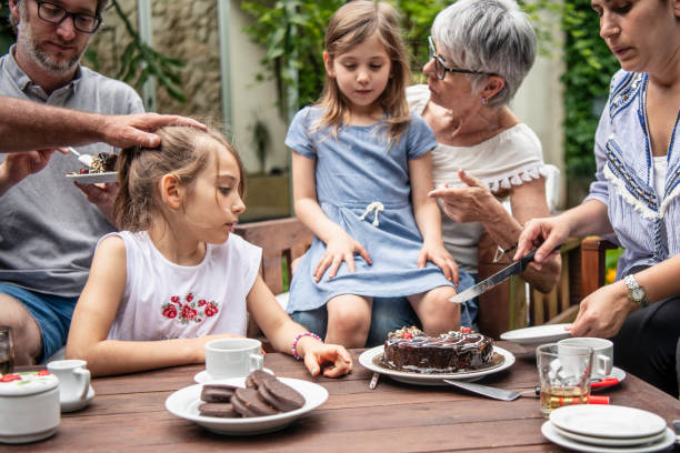 istock Mother cutting cake at daughter's birthday party 1203171702
