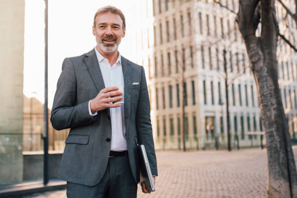 istock Businessman carrying his laptop and drinking coffee 1203171756