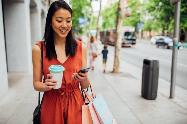 istock Asian girl using phone after shopping 1203171940