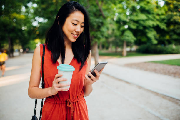 istock Girl drinking coffee and using smartphone at the street 1203171942