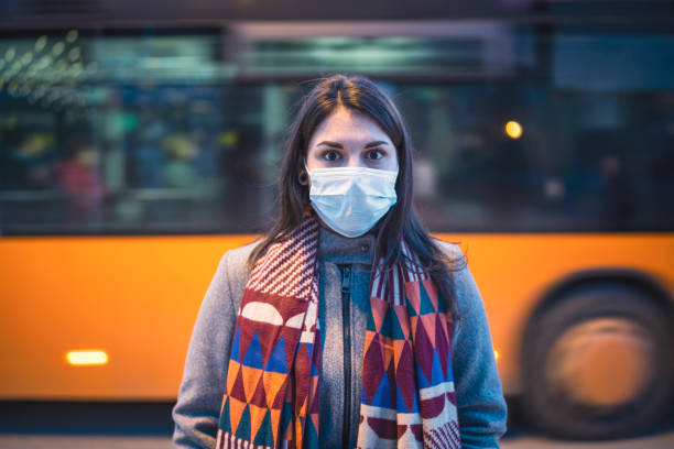 woman wearing protective face mask in town - swine flu fotos imagens e fotografias de stock