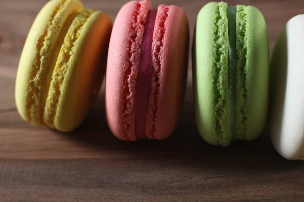 istock colored French cakes on a textured wooden background 1203174810