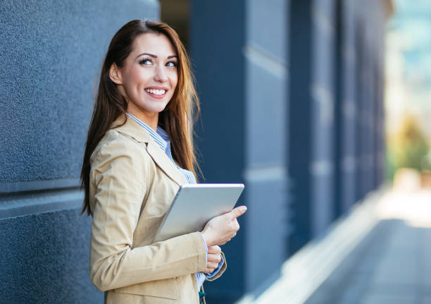 istock Businesswoman holding digital tablet and smiling 1203176523