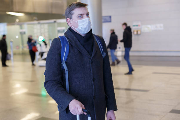 istock Young European man in gray coat, protective disposable medical 1203177162