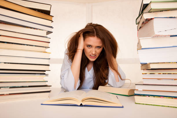 istock attractive young woman student undre stress while studiing for exames 1203177248