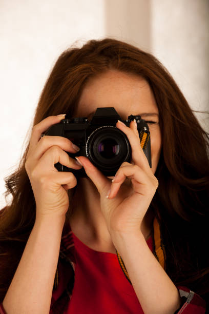 istock attractive beautiful woman holding a retro camera 1203177453