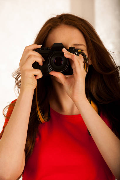 istock attractive beautiful woman holding a retro camera 1203177486