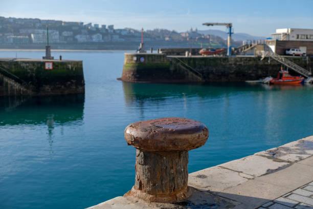 Old rusty mooring bollard on the moorings and pier background in port of San Sebastian, Spain.