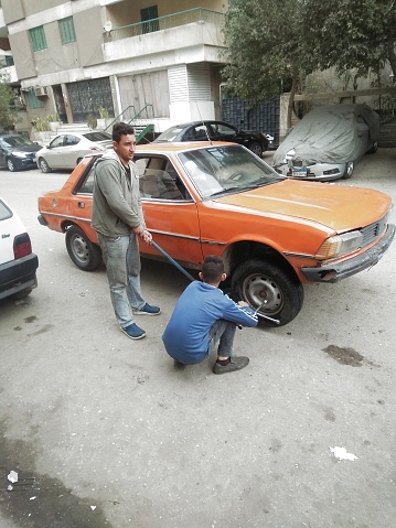 Cairo / Egypt - 01.31:2020: Workers repair car tire in the street of Cairo city - Egypt