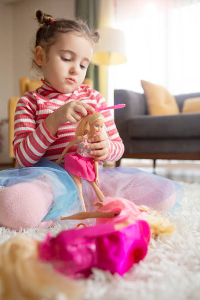 Little girl playing with dolls A little girl playing with dolls girl playing with doll stock pictures, royalty-free photos & images
