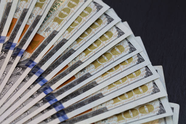 istock fan of 100 dollar banknotes on slate tray 1203183362