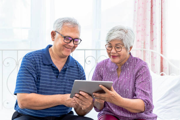 istock Senior couple  man and woman holding and using digital tablet 1203185962