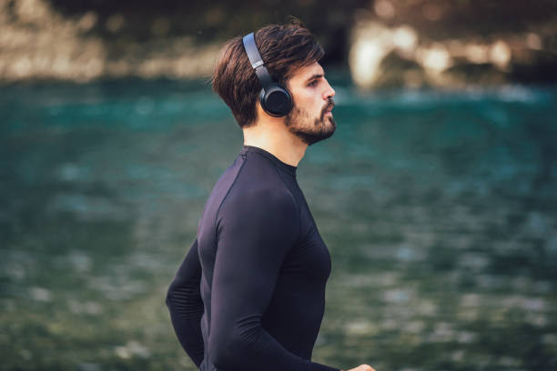 istock Handsome young man jogging on river bank 1203186098
