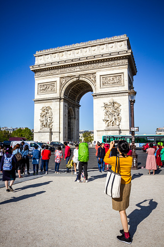 Paris/France - September 10, 2019 : Tourist taking pictures in front of Arc de Triomphe on place de l’Etoile