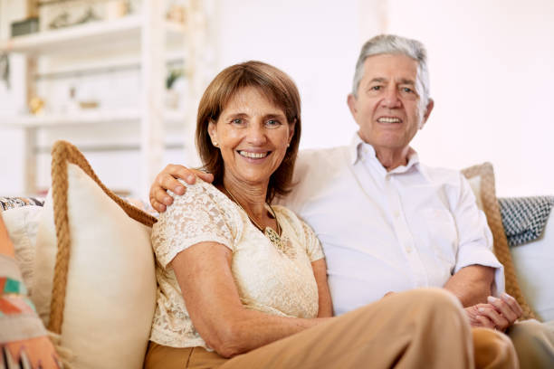 istock Senior couple sitting in the sofa and posing for the camera. 1203187534