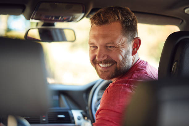 Father Turning Round To Talk To Children In Back Seat On Car Journey Father Turning Round To Talk To Children In Back Seat On Car Journey northern europe family car stock pictures, royalty-free photos & images