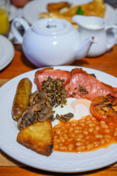 istock Full Scottish breakfast with bacon, fried egg, beans, tomato, roasted sausage, pudding, hash browns and haggis 1203189463