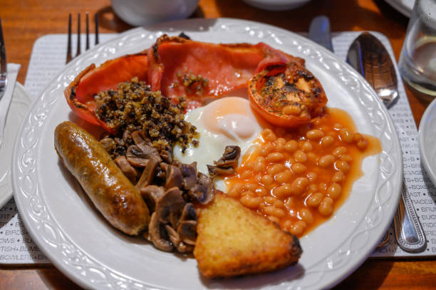 istock Full Scottish breakfast with bacon, fried egg, beans, tomato, roasted sausage, pudding, hash browns and haggis 1203189502