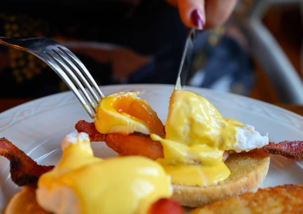 istock Weekend brunch in Scotland with two eggs benedict on homemade muffuns with roasted bacon and yellow hollandaise sauce. 1203190024