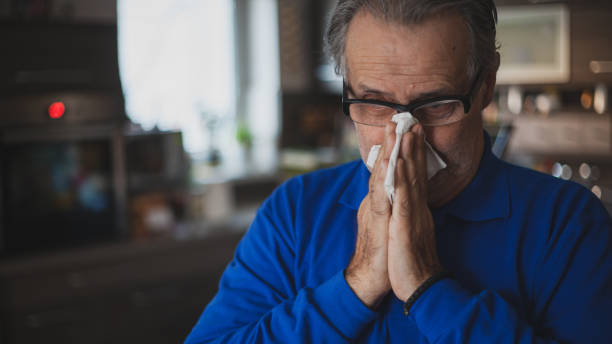 istock Senior man have allergy and blowing nose with tissue 1203192197