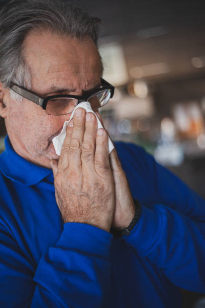istock Senior man have allergy and blowing nose with tissue 1203192859
