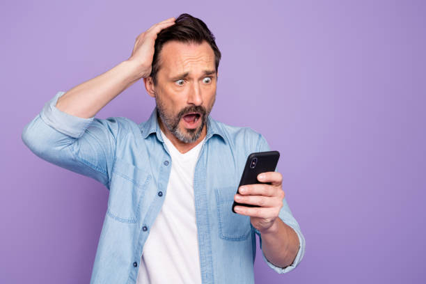istock Omg it unbelievable. Astonished sad man use smartphone read blogging feedback feel frustrated scream wear casual style clothing isolated over purple color background 1203193122