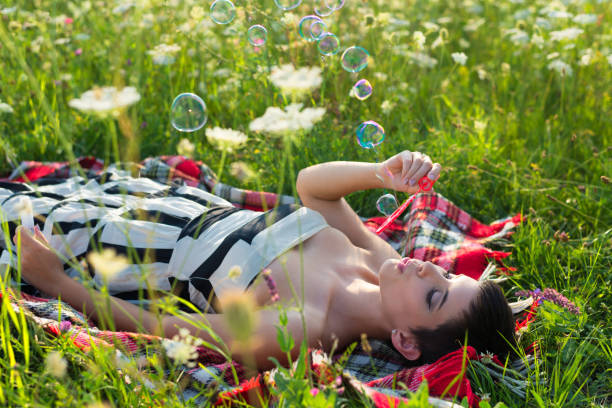 istock Woman making soap bubbles on the summer meadow 1203193617