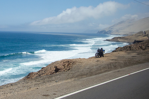 A Motorbike next to the Panamericana. In the back is the majestic Pafific ocean.