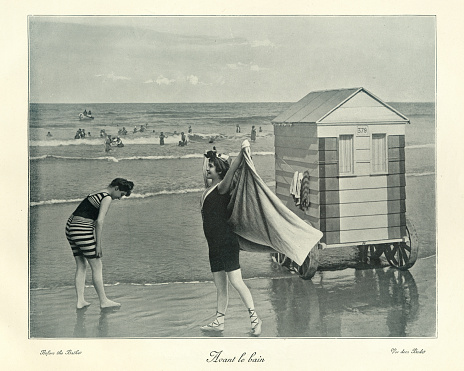 Antique photograph, Victorian Bathing machine, women in swimwear, seaside, 19th Century. The bathing machine was a device, popular from the 18th century until the early 20th century, to allow people to change out of their usual clothes, change into swimwear, and wade in the ocean at beaches. Bathing machines were roofed and walled wooden carts rolled into the sea.