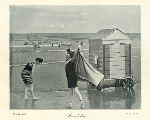 Victorian Bathing machine, women in swimwear, seaside, 19th Century Antique photograph, Victorian Bathing machine, women in swimwear, seaside, 19th Century. The bathing machine was a device, popular from the 18th century until the early 20th century, to allow people to change out of their usual clothes, change into swimwear, and wade in the ocean at beaches. Bathing machines were roofed and walled wooden carts rolled into the sea. beach hut photos stock pictures, royalty-free photos & images