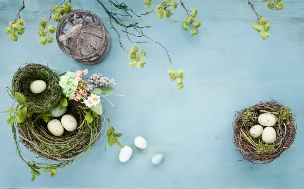 Photo of Easter Bird Nest with Easter Eggs on Rustic Blue Wood Background