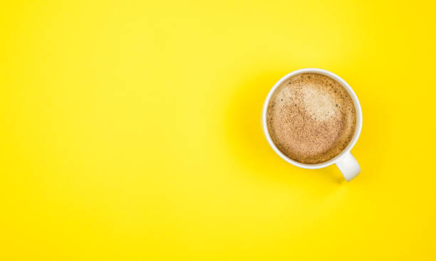 istock A cup of black coffee on yellow background. View from above. copy space 1203196239