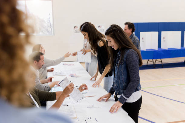 women stand in row while signing up to vote - jovens a votar imagens e fotografias de stock