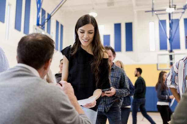 istock Mid adult woman listens as unrecognizable volunteer explains document 1203196297