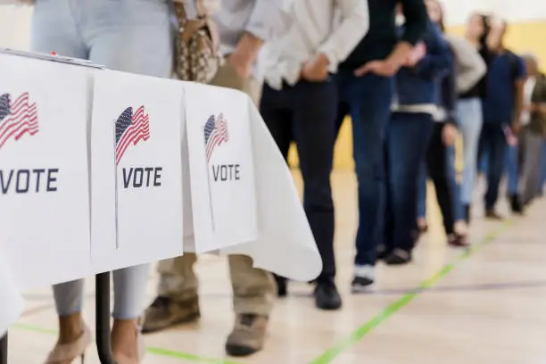 Photo of Low angle view of people lined up to vote