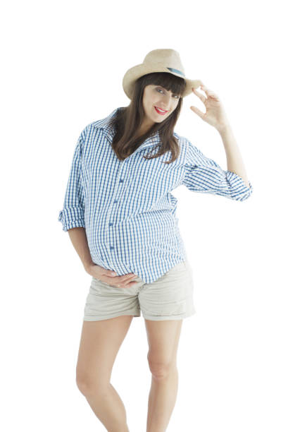 Isolated portrait of pregnant woman in the hat, short and checkered shirt Image of happy pregnant woman touching her big belly. Happy pregnant European woman with big tummy is relaxing. Pregnancy, motherhood, people and expectation concept. Complete family. olivia mum stock pictures, royalty-free photos & images