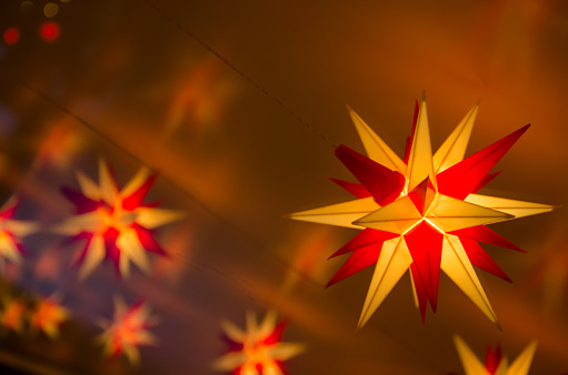 Herrnhut stars. Traditional christmas decoration in Saxony, Germany. The light of the stars is reflected on a window glass behind them.