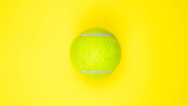 istock New classic single tennis ball isolated on yellow background 1203201050