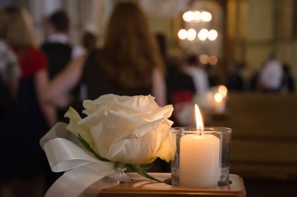 White rose and candle in a church A white rose and a white candle as weddin arrangement in a church place of worship stock pictures, royalty-free photos & images