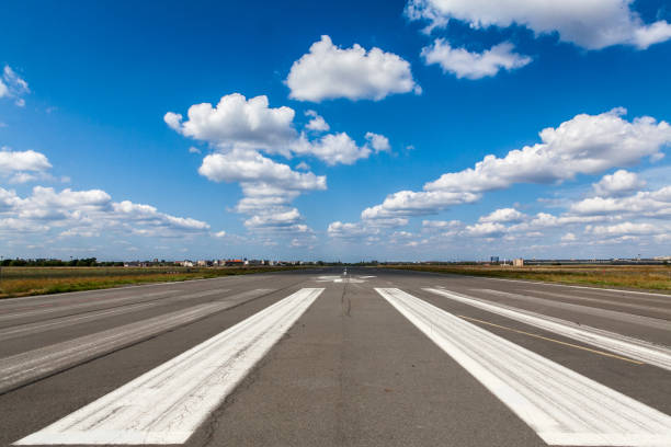 airport runway landing strips against cloudy blue sky - pista de aeroporto imagens e fotografias de stock