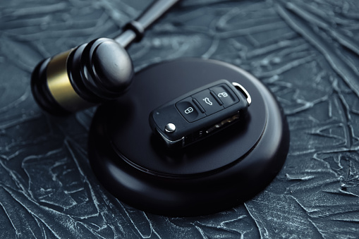 Car auction concept - gavel and car key on the wooden desk