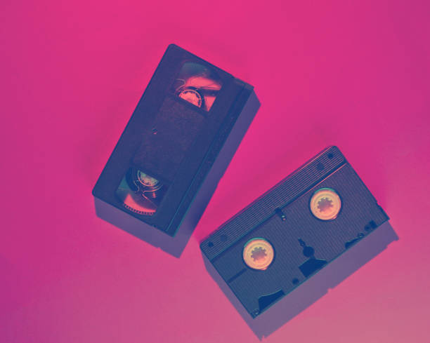 istock Retro wave style two video cassette with neon pink-blue light. 80s. Top view 1203209473