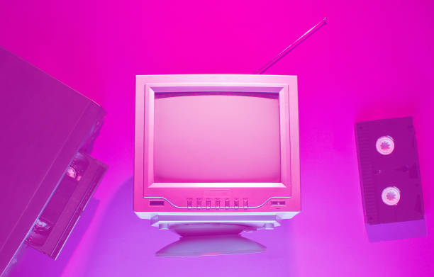 istock Retro wave, 80s concept. Video player with vhs cassette, old tv, neon pink light. Top view, flat lay 1203209762